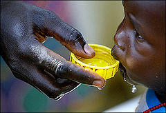 Photo of small child being fed, from Sudan Watch web site