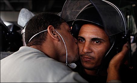 Photo credit: REUTERS/Amr Abdallah Dalsh; Description:  A protester kisses a police officer during a demonstration in Cairo.