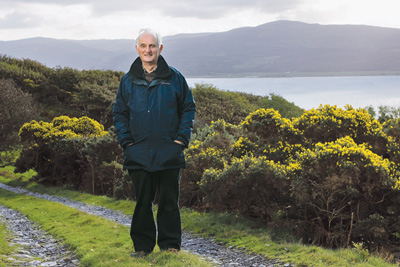 picture of John Houghton overlooking a valley with water below; credit: OnEarth