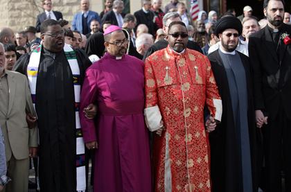 Photo:  The Rev. Charles William, left, the Rev. Wendell Gibbs Jr. , the Rev. Kenneth Flowers and Imam Hassan Al-Qazwini held hands in front of the Islamic Center of America in Dearborn to show unity and condemn a Florida pastor whose church burned a Quran.  credit:  William Archie