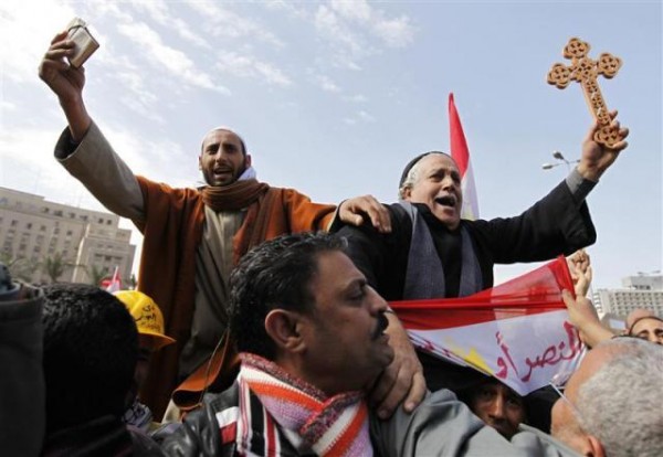Photo credit: Dylan Martinez; Description: A Muslim holding the Koranand a Coptic Christian holding a cross in Tahrir Square in Cairo February 6, 2011