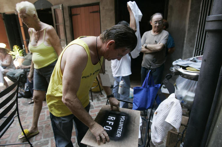 Residents of the Faubourg Marigny neighborhood of New Orleans printed T-shirts during a community meeting on Sept. 9, 2005. The neighborhood organized a cleanup effort even as mandatory evacuation of the city was under way. Refusing to obey the order to evacuate, many residents remained in their houses.  Photo credit:  Hector Mata/AFP/Getty Images