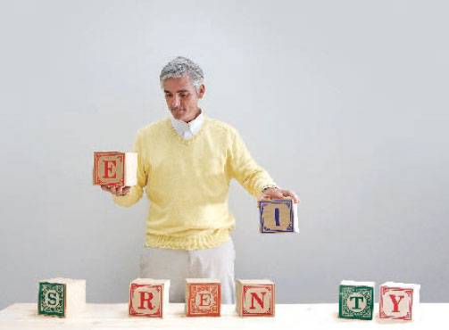 Photo:  Man playing with alphabet blocks, almost spelling the word Serenity