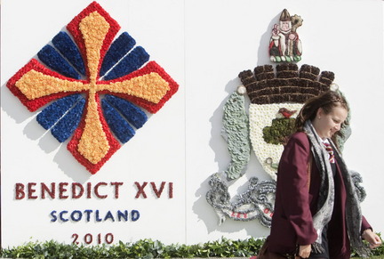 Associated Press photo: A schoolgirl walks by a floral logo next to the stage, in Bellahouston Park, Glasgow, Scotland, prior to the Papal Mass by Pope Benedict XVI, Wednesday, Sept. 15, 2010. Pope Benedict XVI will begin a four-day visit, the first-ever state visit by a Pope to Britain on Thursday.