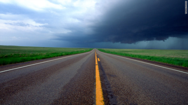 Photo credit: Thinkstock; Description: highway on the plains beneath storm clouds